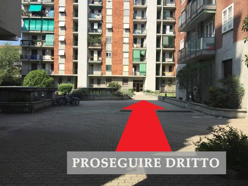 Vialetto pedonale interno con freccia che indica di proseguire dritto