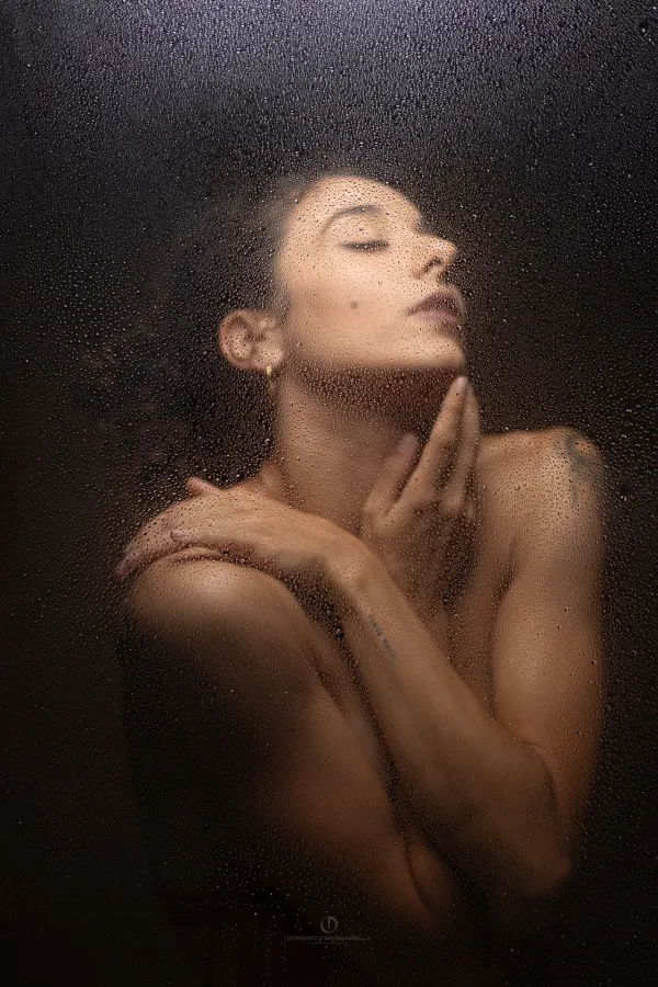 ritratto ragazza dietro vetro con gocce